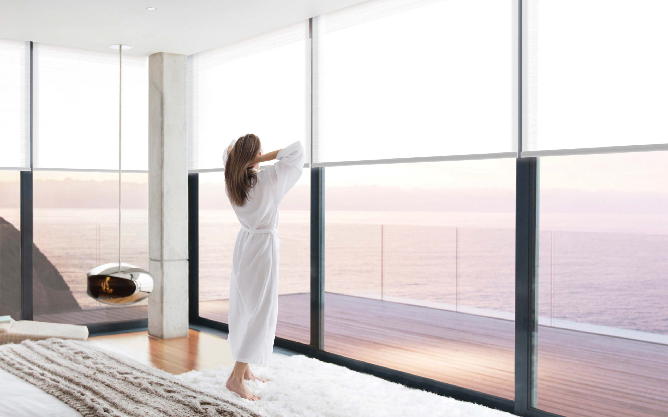 Woman wearing bathrobe in modern bedroom